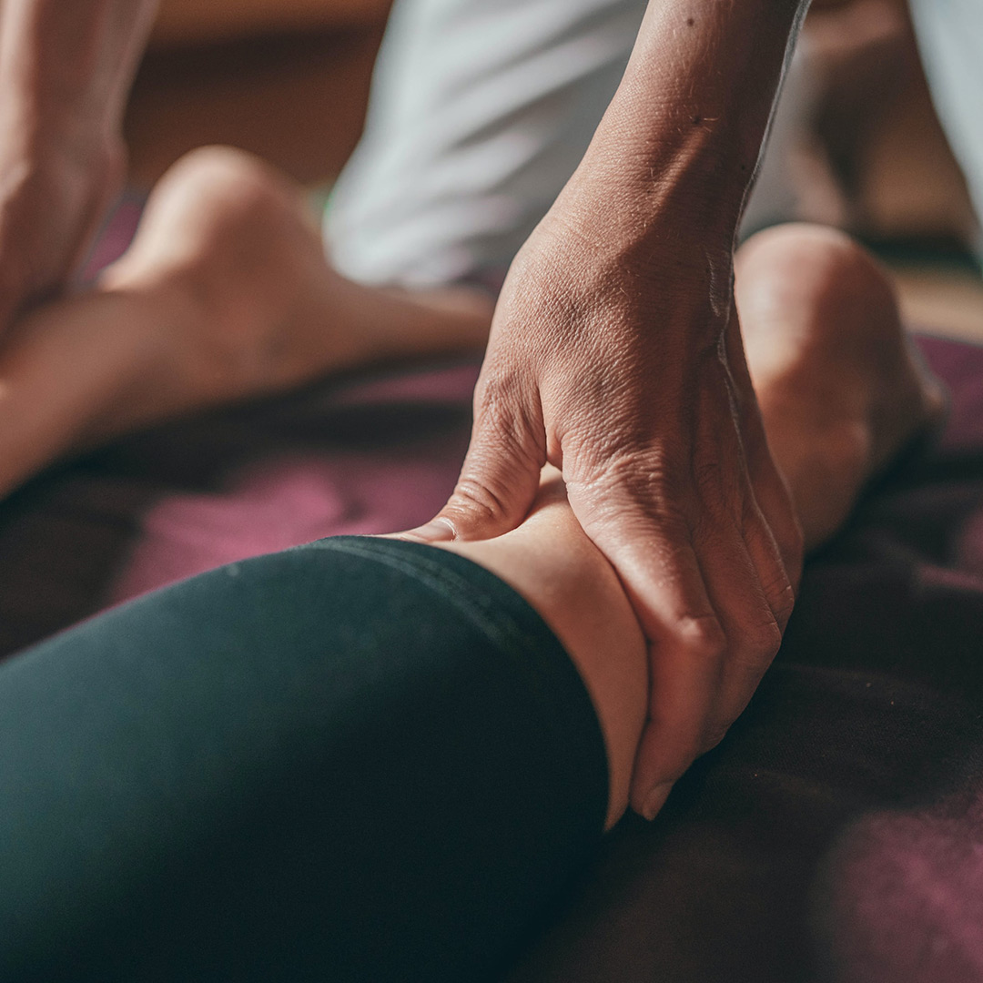 An image of someone receiving gentle massage on the backs of their legs. 